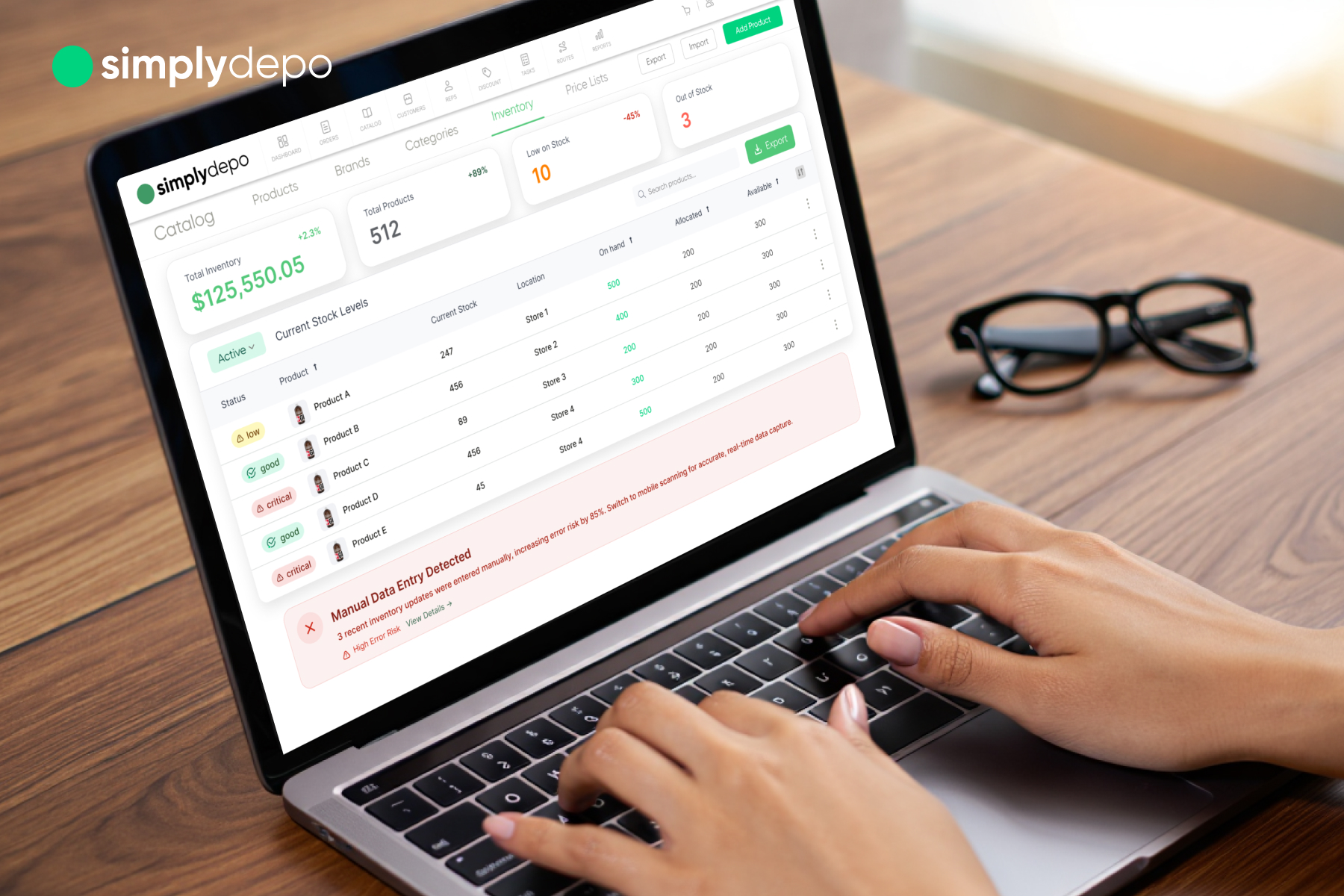 A laptop user reviews the SimplyDepo dashboard showing sales, products, financials, and a manual entry alert; glasses on desk.