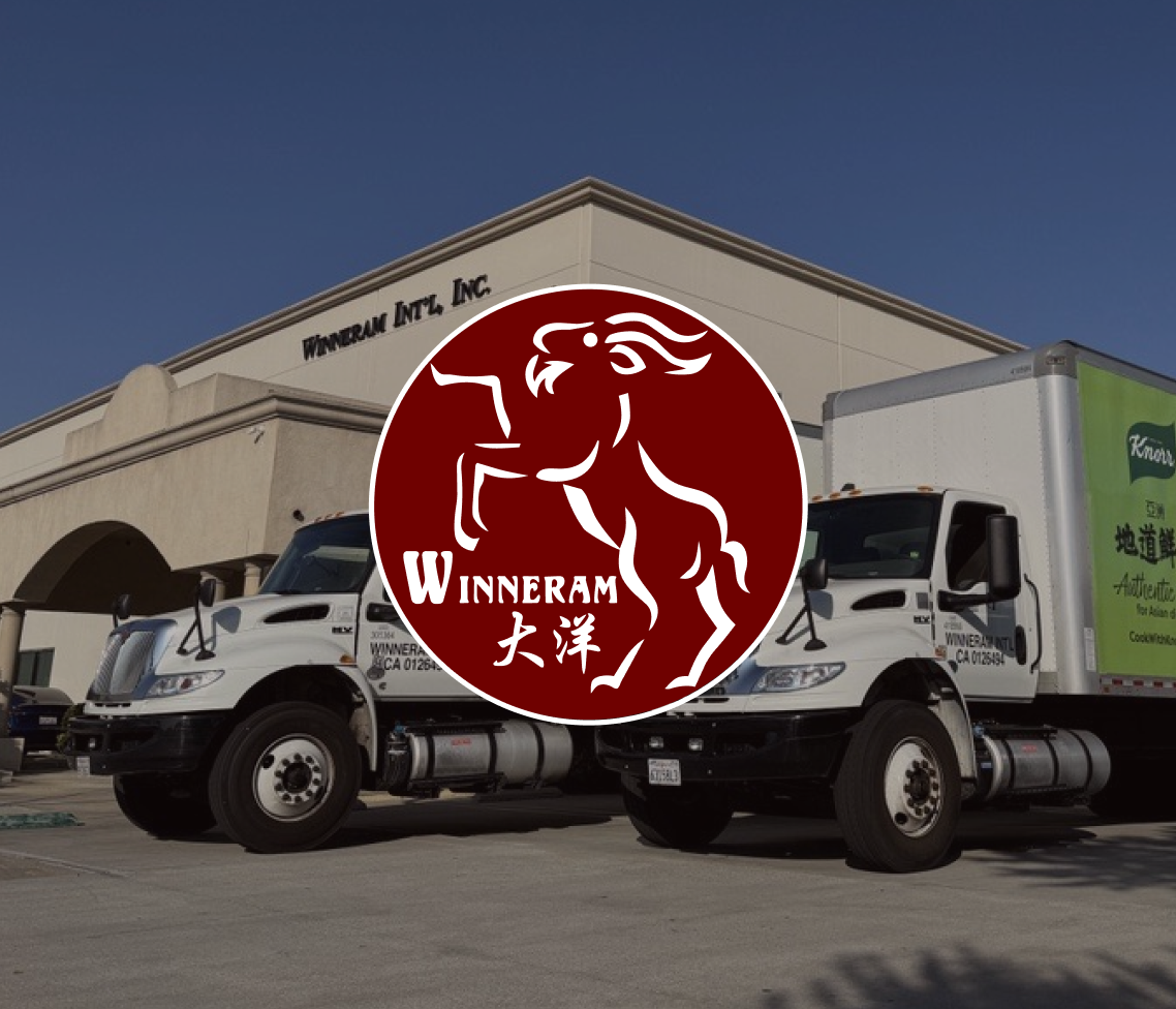 Two Winneram International trucks parked by a beige building with company name, overlaid by a maroon leaping ram Winneram logo.